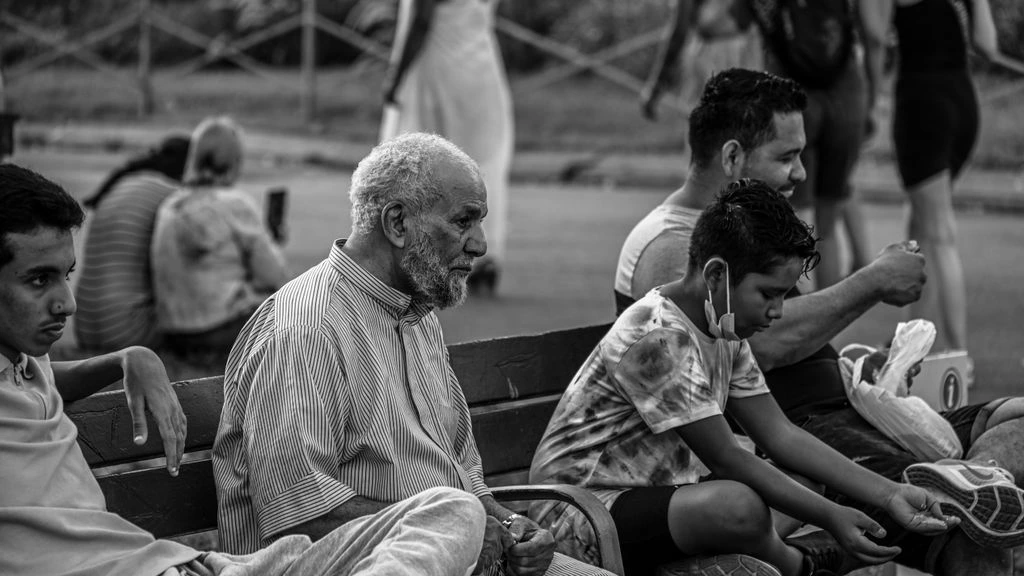 A multigenerational family shares a meal in a sunlit courtyard in Oaxaca, Mexico